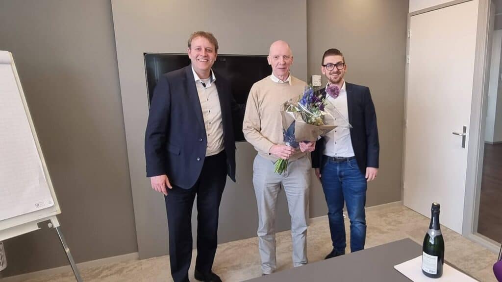 Jochem Mooiman neemt bos bloemen in ontvangst na contractondertekening.